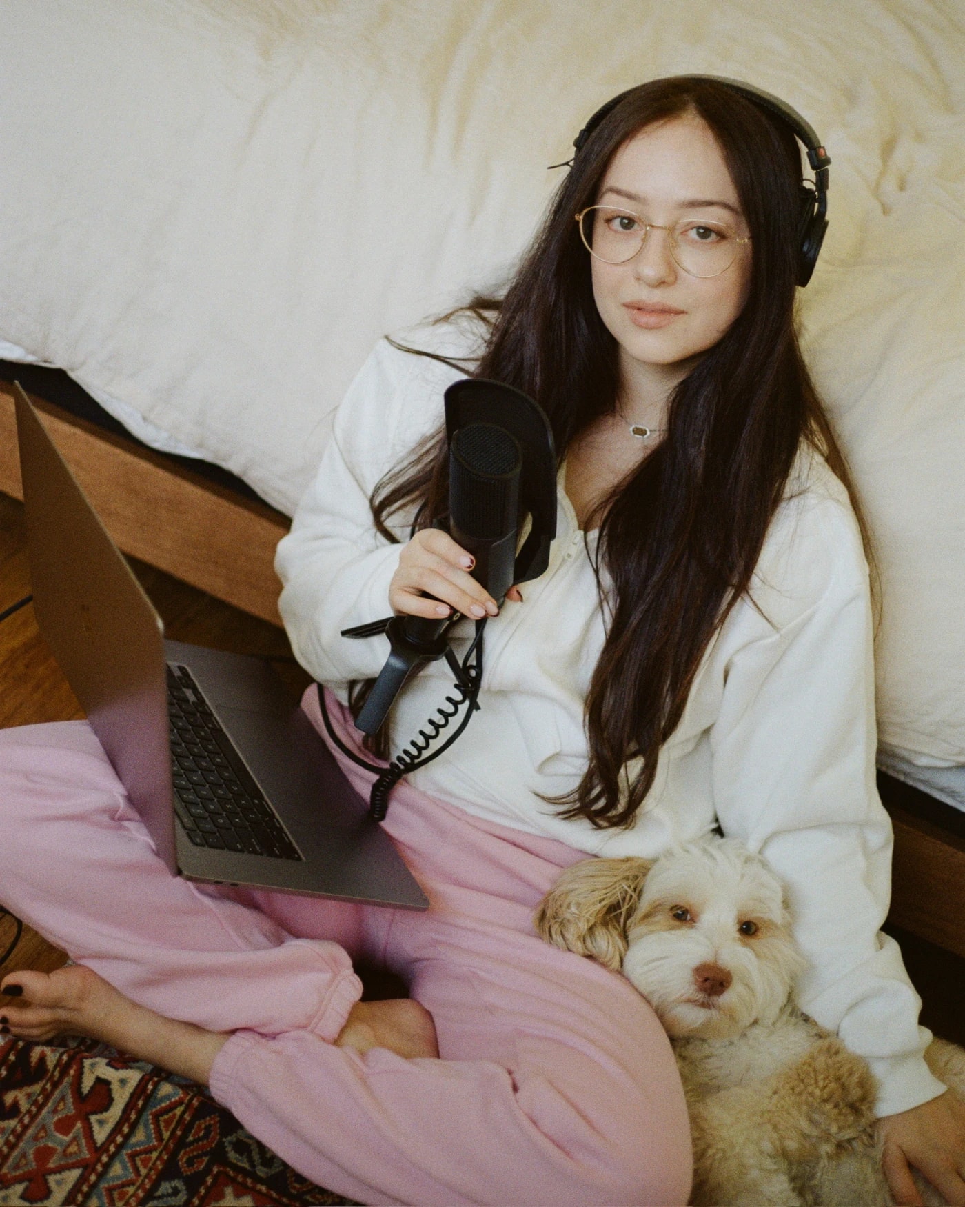 Sia, the founder of MTHR, working from bed with her headphones on.