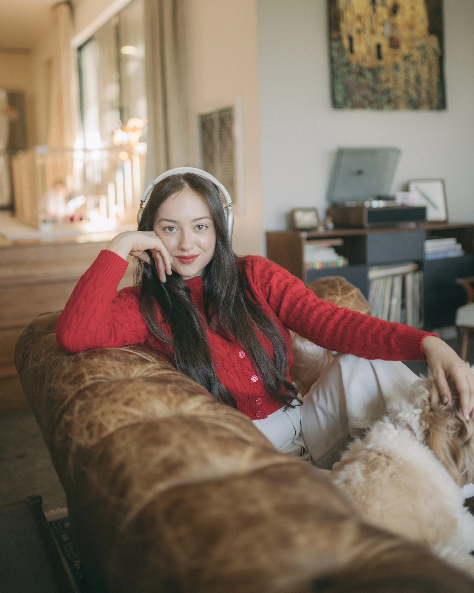 A mother in headphones resting on the sofa at home.